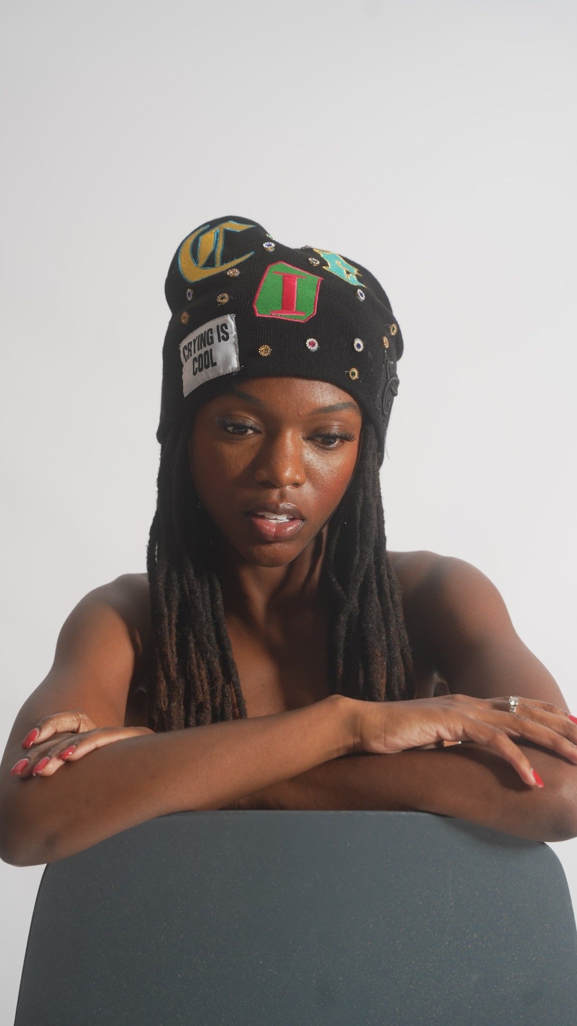 CIC gemstone beanie in black, worn on model, front view with the C I C letters