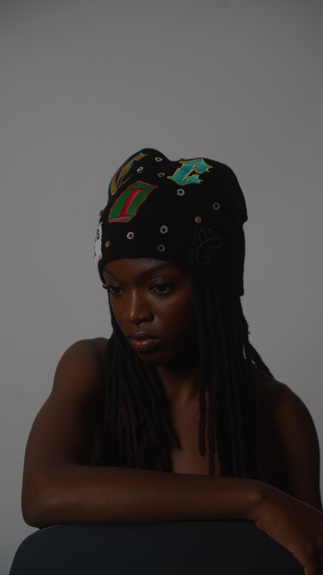 CIC gemstone beanie in black, worn on model, moody light