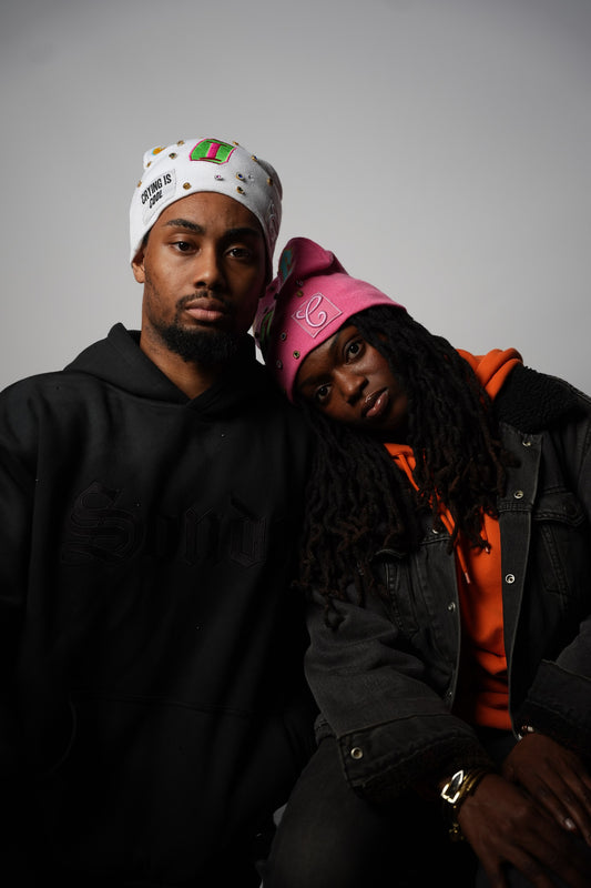 White and pink CIC gemstone beanies, models leaning together