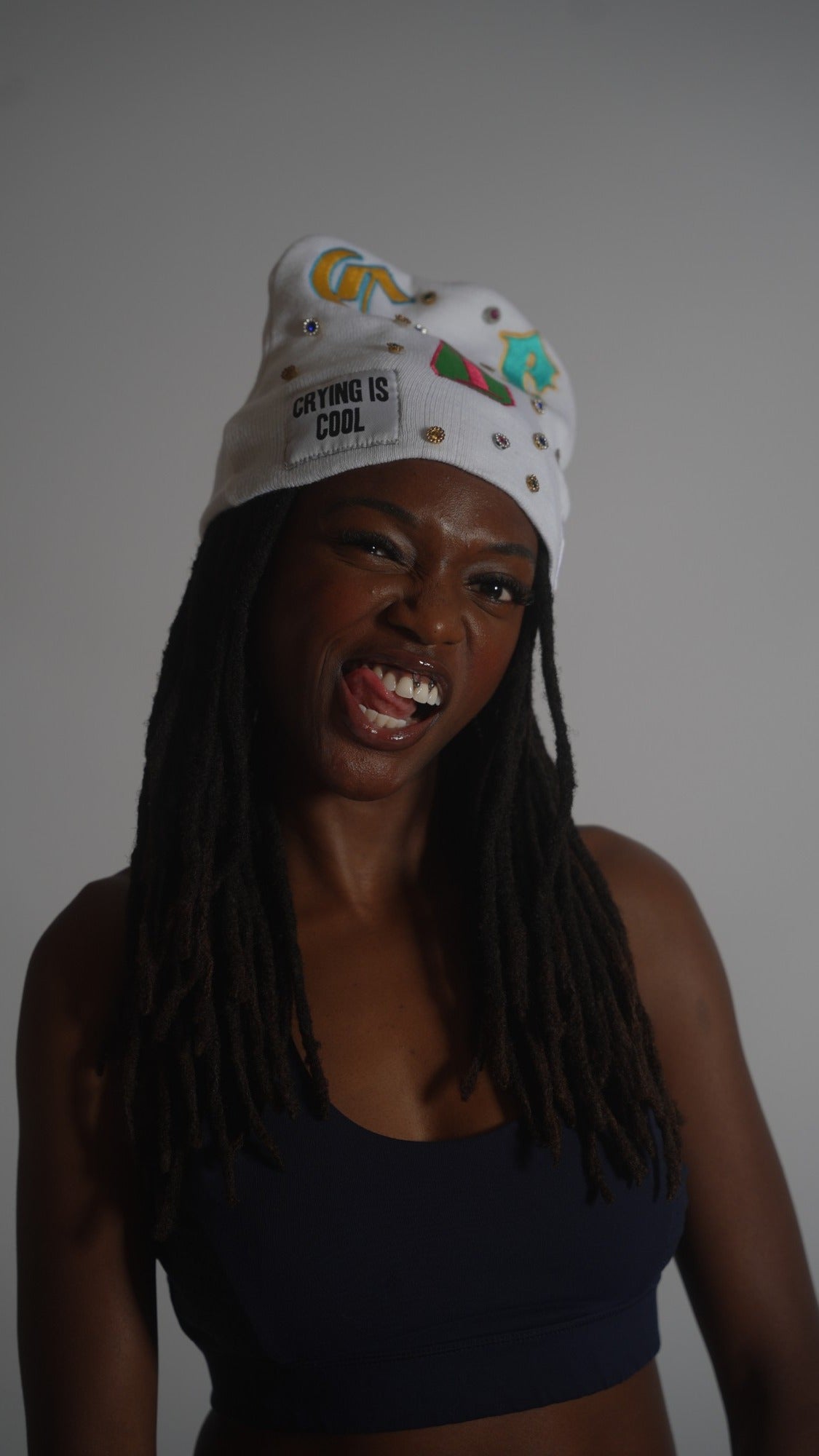 CIC gemstone beanie in white, worn on model with the Crying Is Cool patch